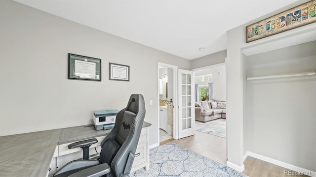 office area with light wood-style flooring, baseboards, and french doors