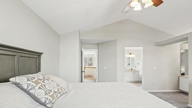 carpeted bedroom featuring lofted ceiling, a ceiling fan, baseboards, a sink, and connected bathroom