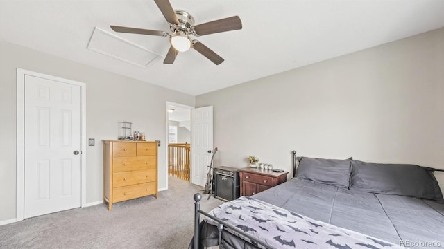 bedroom with ceiling fan, light carpet, attic access, and baseboards