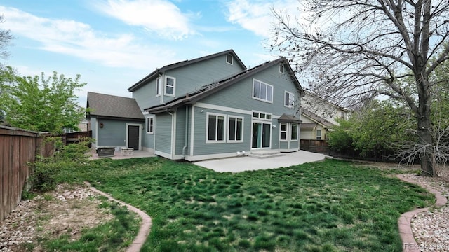 rear view of house with a yard, a patio, and a fenced backyard