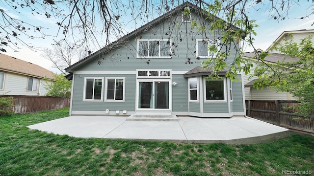 rear view of house with a yard, a patio area, and fence