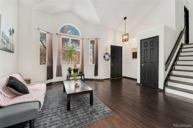 living room with high vaulted ceiling, dark hardwood / wood-style floors, and a chandelier