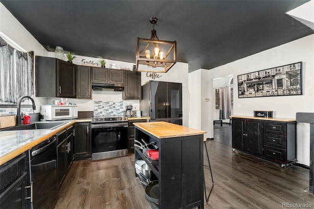 kitchen featuring pendant lighting, sink, wooden counters, black appliances, and a kitchen island