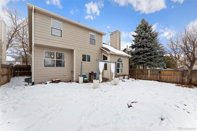 view of snow covered rear of property