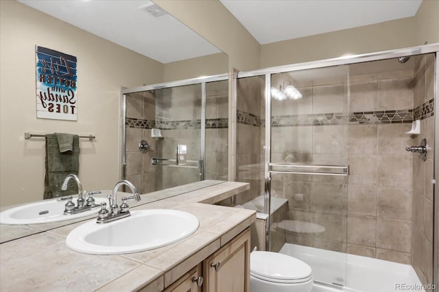 bathroom with toilet, a stall shower, visible vents, and vanity