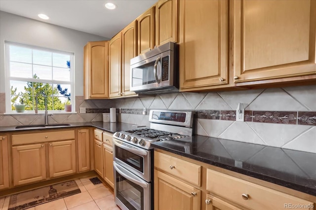 kitchen with stainless steel appliances, recessed lighting, backsplash, light tile patterned flooring, and a sink