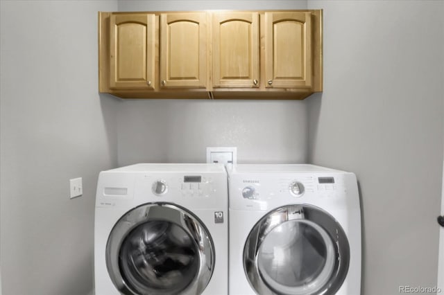 washroom featuring cabinet space and separate washer and dryer