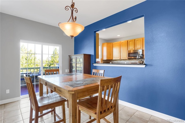 dining room featuring light tile patterned floors and baseboards