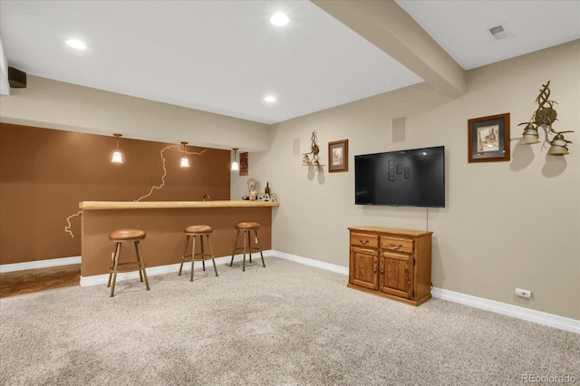 bar featuring visible vents, wet bar, baseboards, and carpet flooring