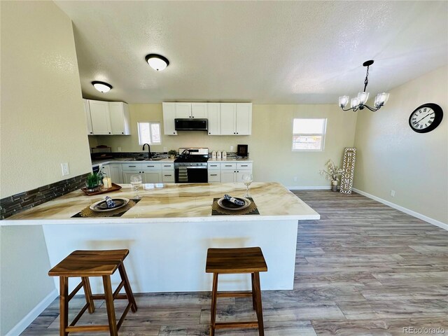 kitchen featuring stainless steel appliances, plenty of natural light, kitchen peninsula, and a kitchen breakfast bar