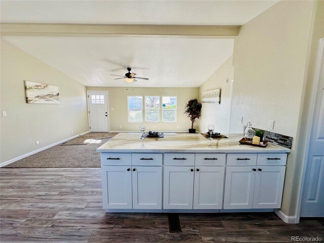 kitchen with lofted ceiling, dark hardwood / wood-style flooring, ceiling fan, and white cabinets