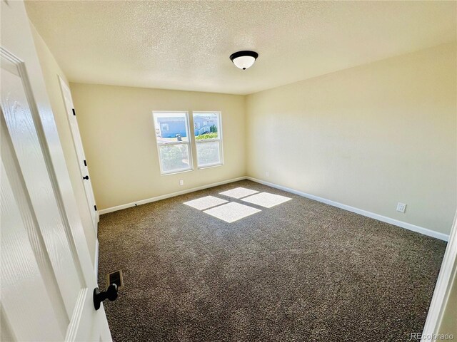 spare room with carpet floors and a textured ceiling