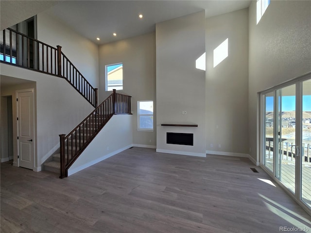 unfurnished living room with hardwood / wood-style floors and a high ceiling