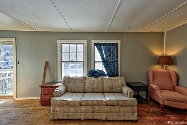 living room with wood walls, dark wood-type flooring, and a textured ceiling