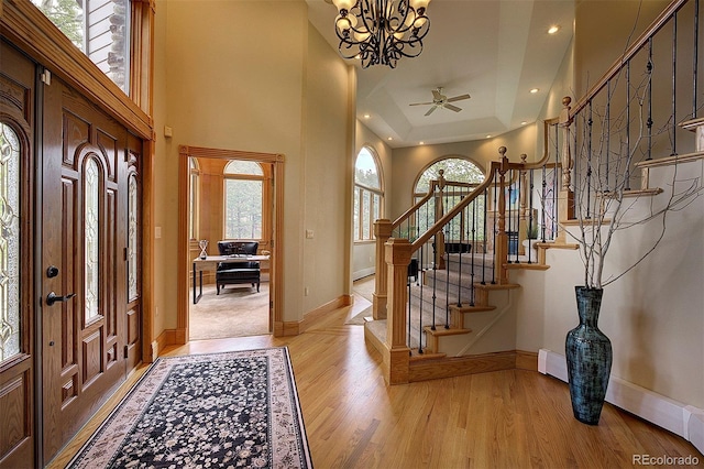 2191 Baldy Ln, Evergreen, CO 80439 - entrance foyer with light wood-style flooring, stairway, a chandelier, a raised ceiling, and baseboard heating