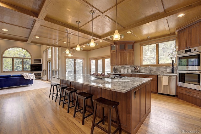2191 Baldy Ln, Evergreen, CO 80439 - kitchen featuring appliances with stainless steel finishes, wood ceiling, open floor plan, coffered ceiling, and brown cabinetry