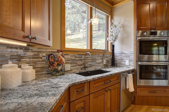 2191 Baldy Ln, Evergreen, CO 80439 - kitchen featuring appliances with stainless steel finishes, brown cabinets, tasteful backsplash, light stone counters, and ornamental molding