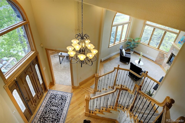 2191 Baldy Ln, Evergreen, CO 80439 - foyer entrance with wood finished floors, a chandelier, stairs, and a high ceiling