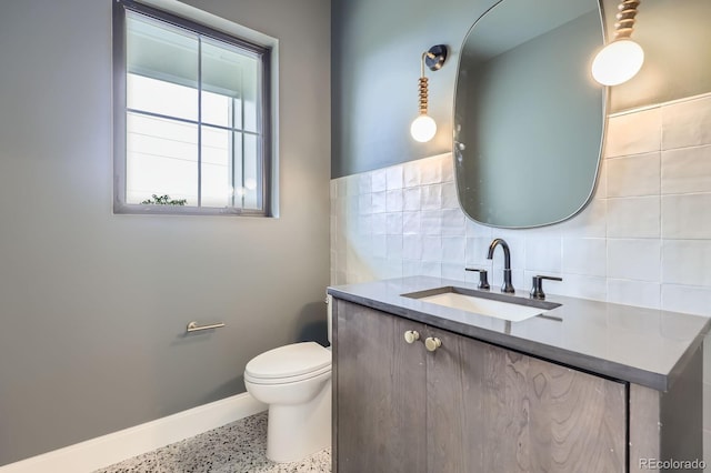 3019 Chase St, Wheat Ridge, CO 80214 - half bathroom with speckle patterned floor, vanity, baseboards, tasteful backsplash, and toilet