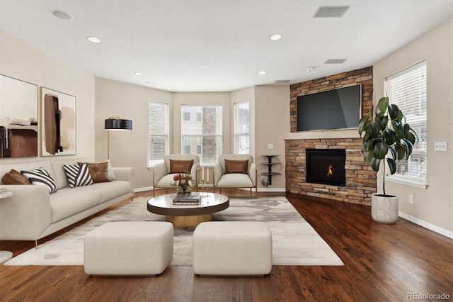 living area with a fireplace, baseboards, wood finished floors, and recessed lighting