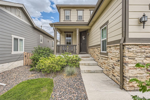 entrance to property with stone siding and covered porch