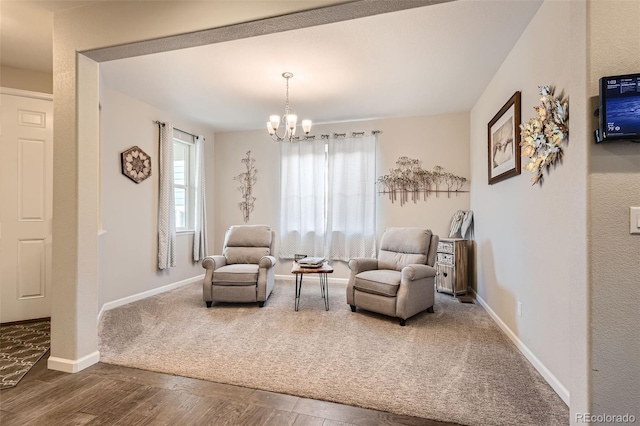 sitting room featuring an inviting chandelier, wood finished floors, and baseboards