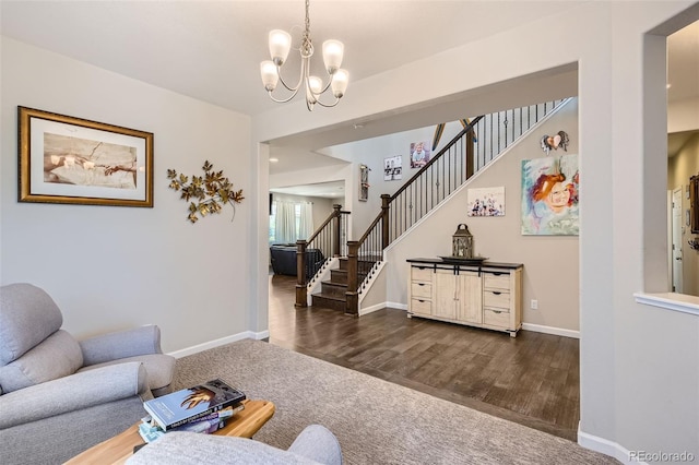 living area featuring a notable chandelier, baseboards, and stairs