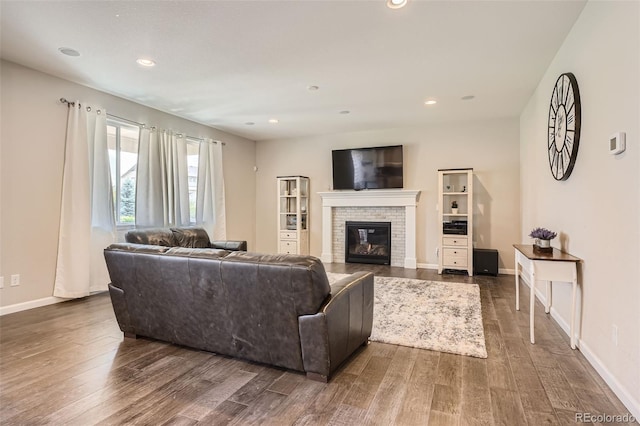 living room featuring recessed lighting, a fireplace, dark wood finished floors, and baseboards