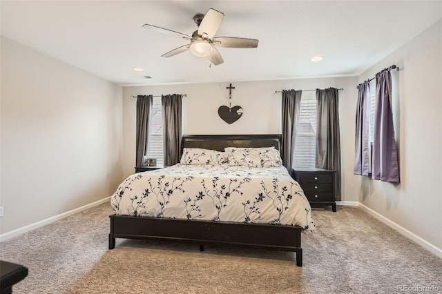 bedroom with light carpet, ceiling fan, visible vents, and baseboards