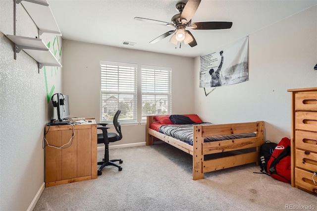 carpeted bedroom with a ceiling fan, visible vents, and baseboards