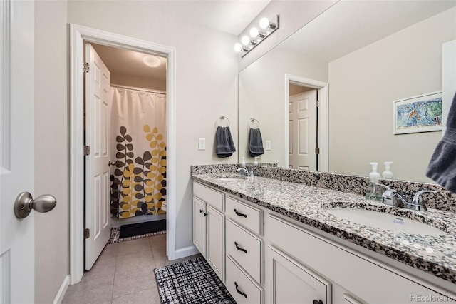 bathroom featuring double vanity, tile patterned flooring, baseboards, and a sink