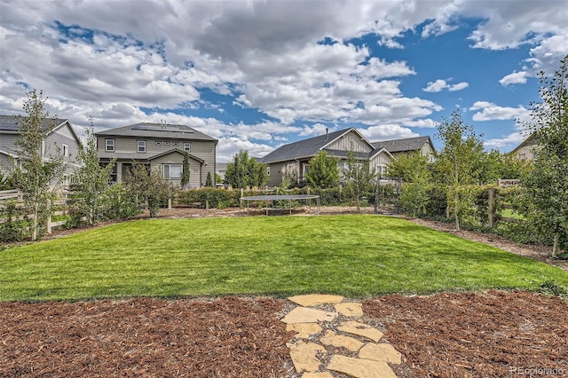 view of yard featuring a trampoline and fence