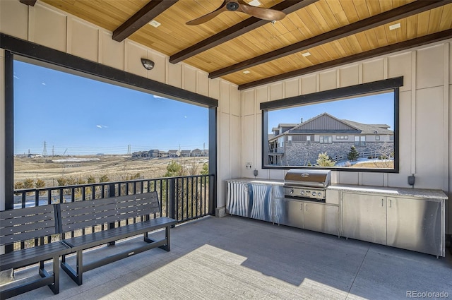 view of patio featuring a ceiling fan, exterior kitchen, and area for grilling