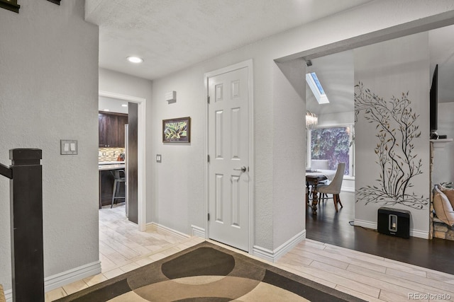 foyer featuring a skylight and wood-type flooring