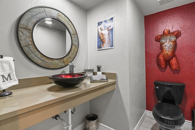 bathroom featuring toilet and sink