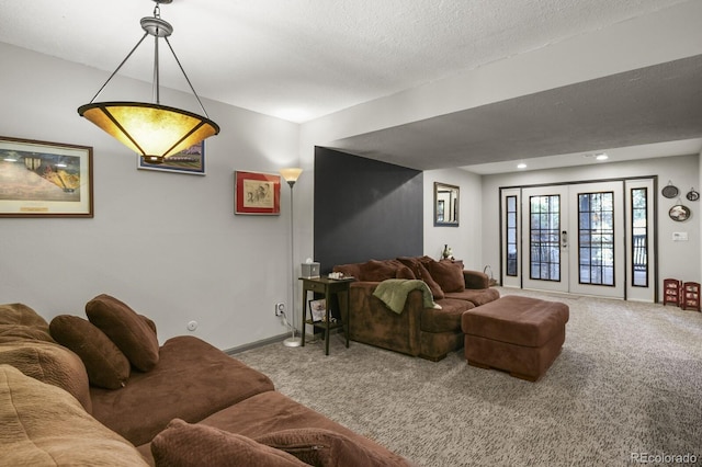 carpeted living room with french doors and a textured ceiling