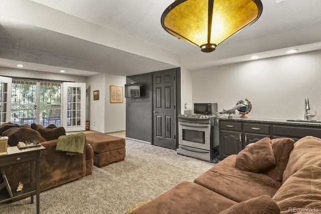 carpeted living room with a textured ceiling and sink