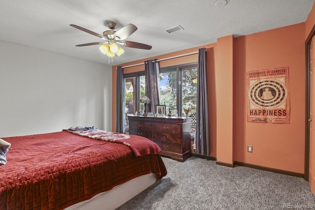 carpeted bedroom with ceiling fan and a textured ceiling