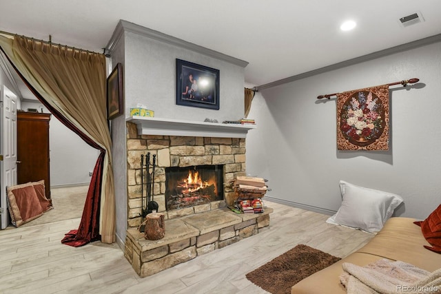 living room with crown molding, a fireplace, and light hardwood / wood-style flooring