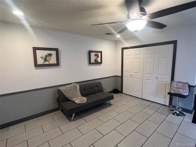 sitting room featuring ceiling fan and a textured ceiling