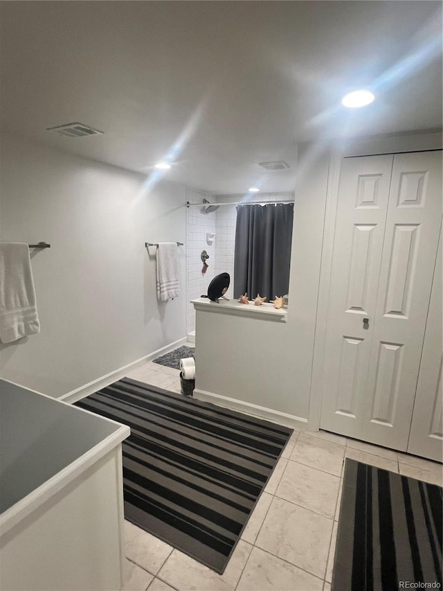 bathroom featuring walk in shower and tile patterned flooring