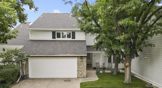 view of front of property with a garage, stone siding, a front yard, and a shingled roof