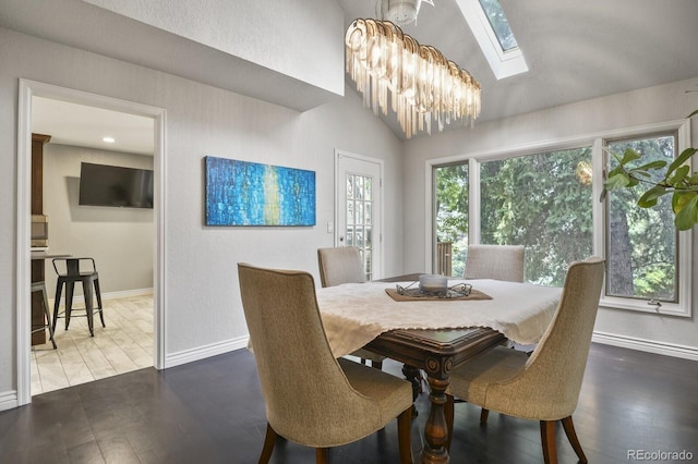 dining space featuring lofted ceiling with skylight, dark wood-type flooring, and a chandelier