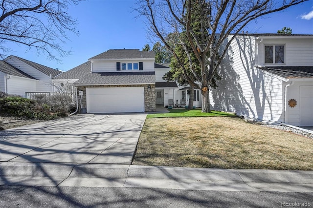 traditional-style house with stone siding, concrete driveway, and a front yard