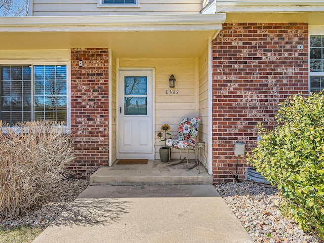 view of exterior entry featuring brick siding