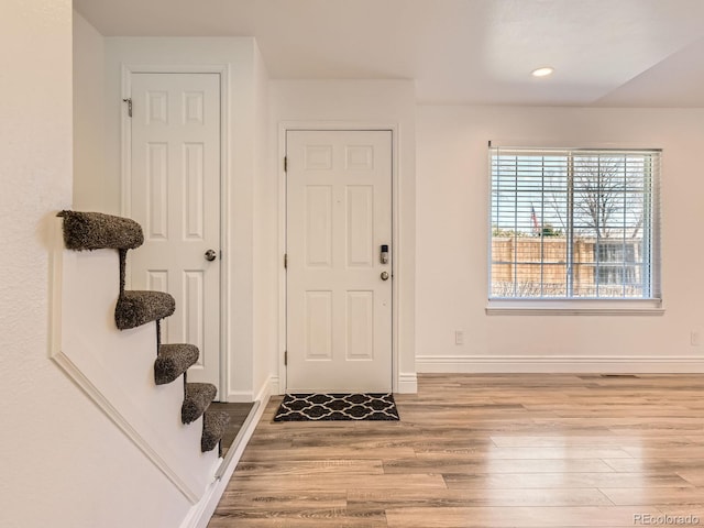 foyer with stairs, recessed lighting, baseboards, and wood finished floors