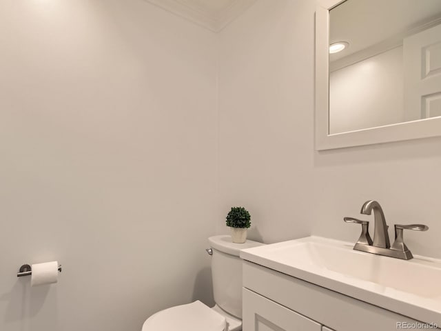 bathroom featuring ornamental molding, vanity, and toilet