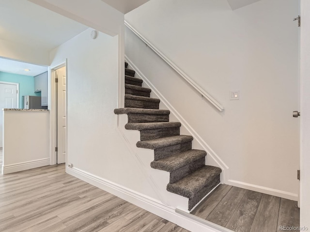 stairway with baseboards and wood finished floors