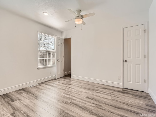 spare room featuring a ceiling fan, baseboards, and wood finished floors