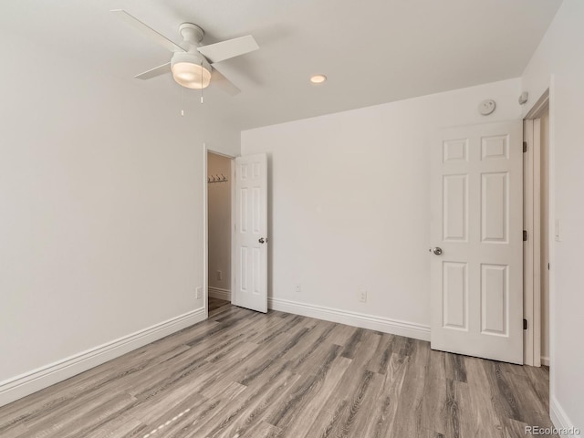 spare room featuring ceiling fan, baseboards, and wood finished floors